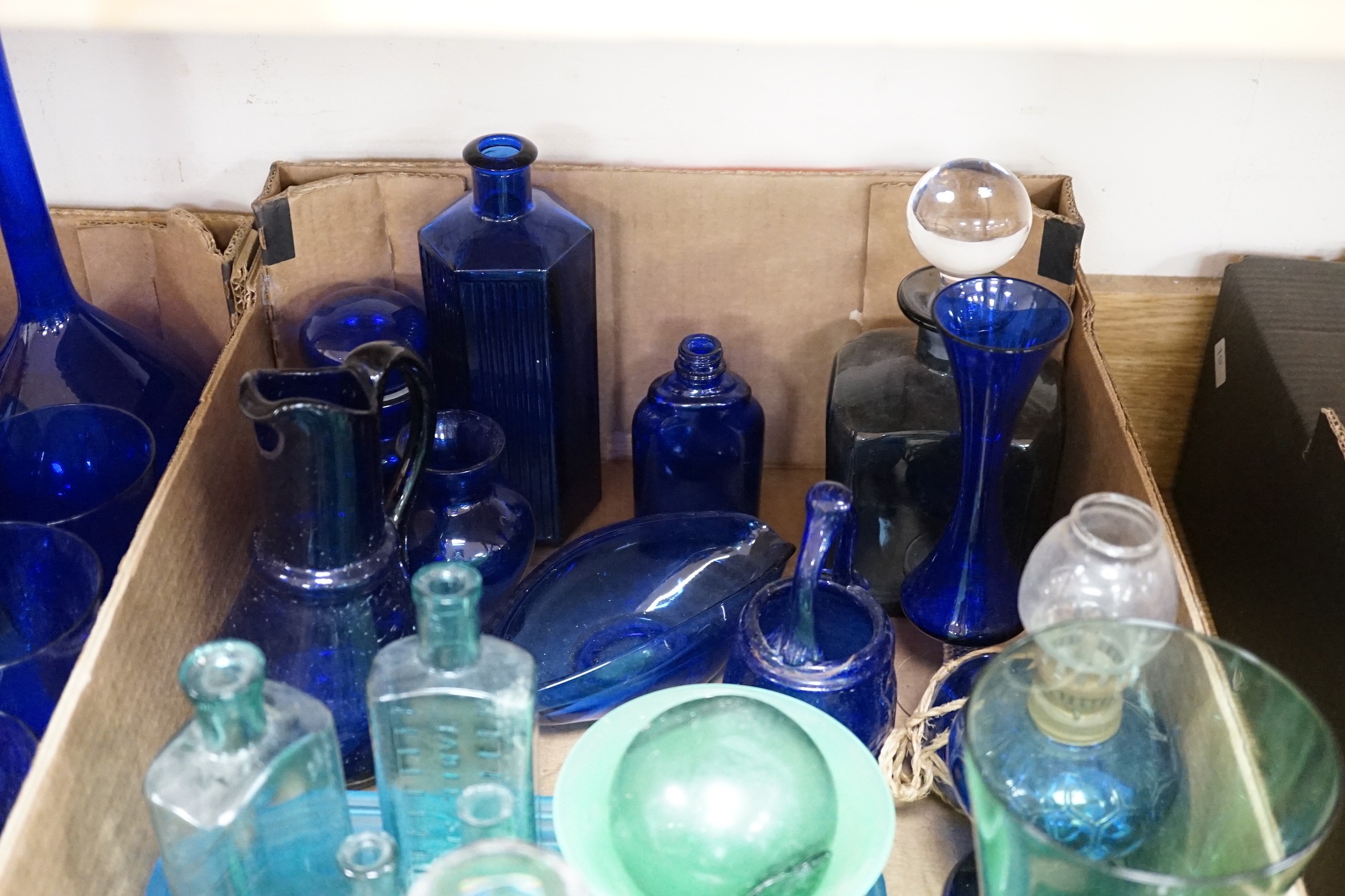 A collection of dark blue, green and turquoise coloured glassware, including three long stemmed glasses